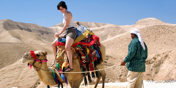WOMAN ON A CAMEL IN THE JUDAEAN DESERT 